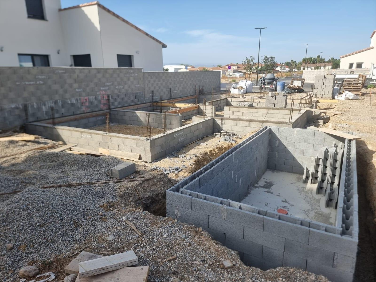 Construction des murs banchés d'une piscine béton à Pia par MCI Construction
