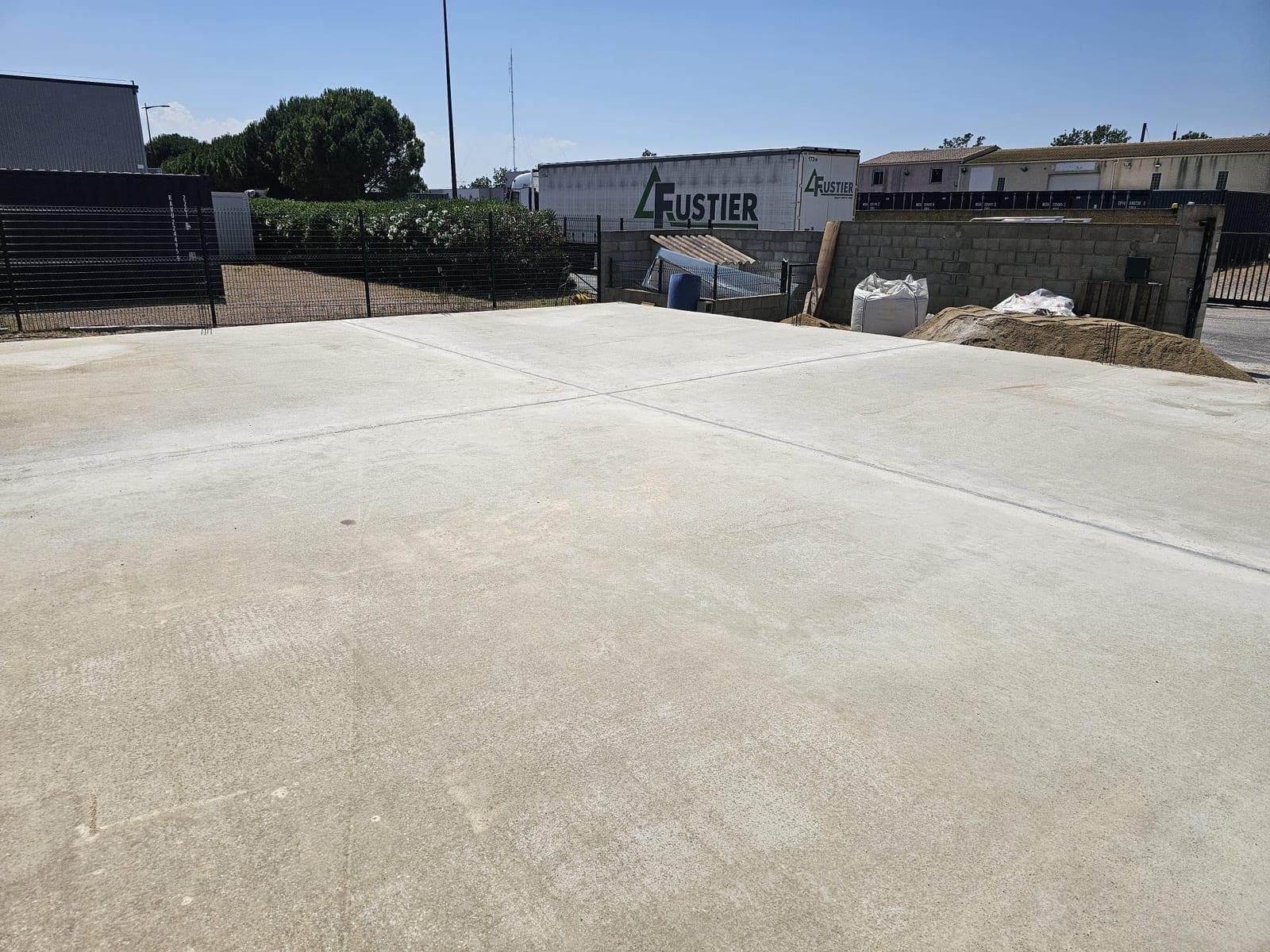 Dalle béton de 15 cm après coulage et nivellement sur une extension de hangar à Coursan