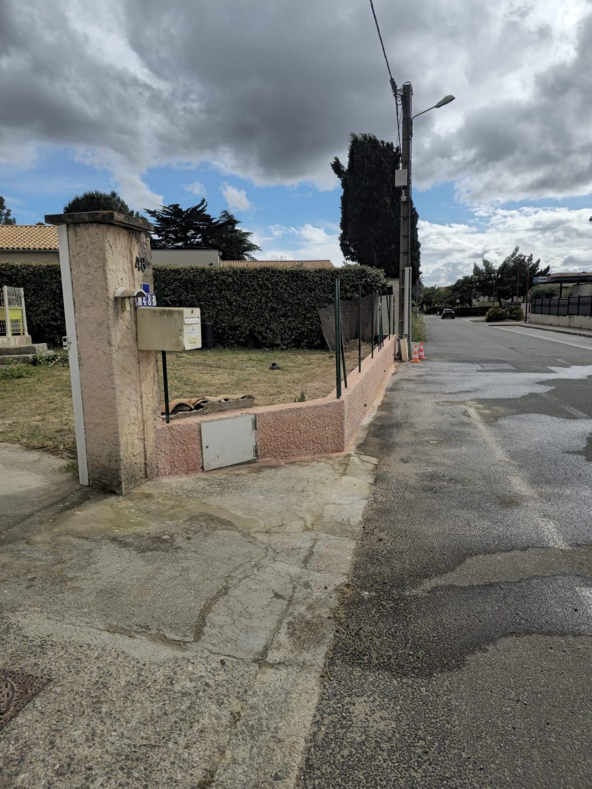 Soubassement du mur de clôture ravalé à la tyrolienne en finition écrasée, avant pose du grillage souple, à Vinassan