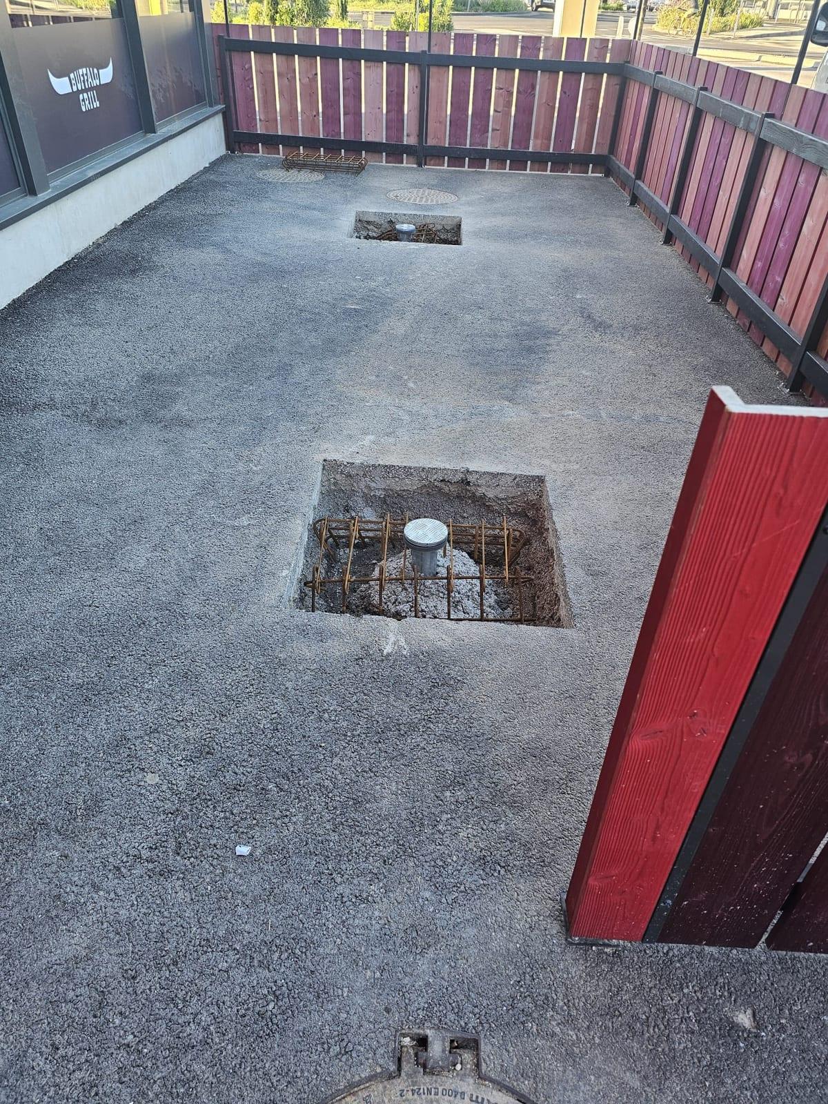 Préparation des massifs béton et positionnement des douilles de parasols sur la terrasse du Buffalo Grill