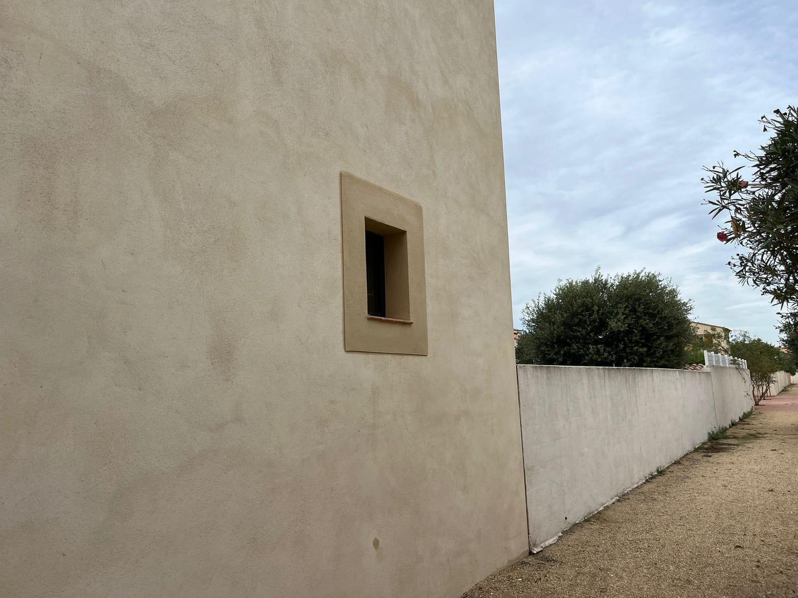 Finition d’enduit sur une façade secondaire et un encadrement extérieur